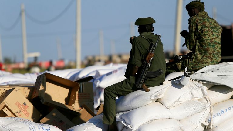 Armed men guard sacks of food delivered to Ethiopian refugees fleeing from the ongoing fighting in Tigray region earlier this week