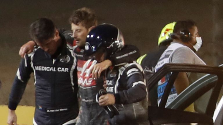 Stewards and medics attend to Haas F1&#39;s French driver Romain Grosjean (C) after a crash at the start of the Bahrain Formula One Grand Prix at the Bahrain International Circuit in the city of Sakhir on November 29, 2020. (Photo by HAMAD I MOHAMMED / POOL / AFP) (Photo by HAMAD I MOHAMMED/POOL/AFP via Getty Images)