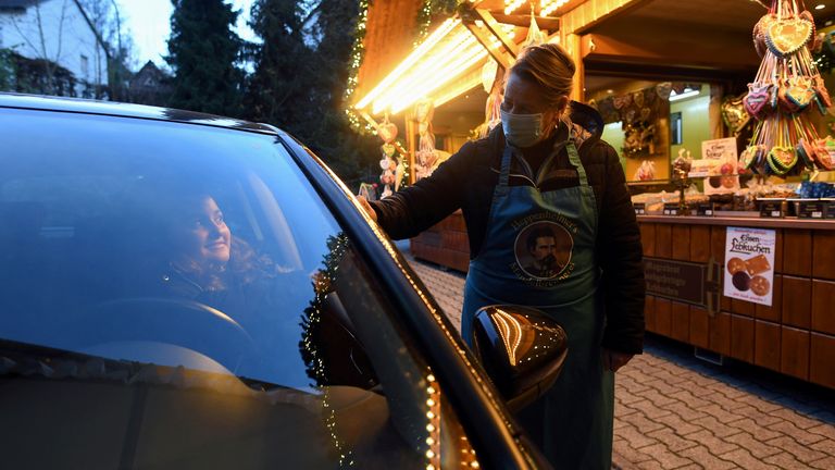 FILE PHOTO: A woman buys food from a booth at a drive-in Christmas market under a large marquee, amid the spread of the coronavirus disease (COVID-19), in Landshut, Germany, November 12, 2020. REUTERS/Andreas Gebert/File Photo