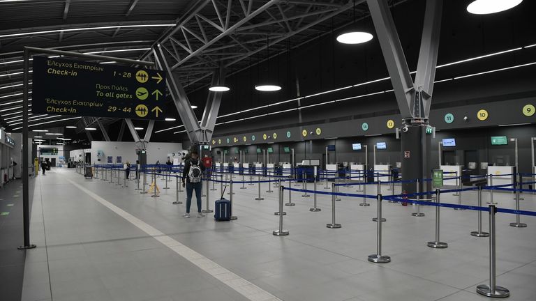 Passenger walks in the airport of Thessaloniki, northern Greece on November 3, 2020. - Greece announced a two-week lockdown on its second largest city of Thessaloniki to try to contain a spike in coronavirus cases. Flights to and from Thessaloniki airport have been suspended under the measure, which came into force early November 3, 2020, and also affects the northern city of Serres. Everything will remain closed, except for schools, and those wanting to leave their homes will have to seek permi