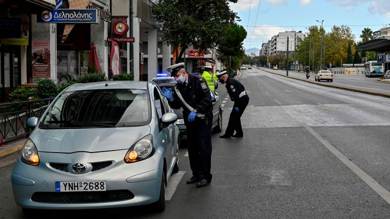 Police checks people&#39;s movement permits at a roadblock in central Athens on November 7, 2020 on the first day of a three-weeks lockdown. - Greek goverment imposed a nationwide lockdown as of November 7, to curb the spread of the Covid-19 (novel coronavirus). (Photo by LOUISA GOULIAMAKI / AFP) (Photo by LOUISA GOULIAMAKI/AFP via Getty Images)