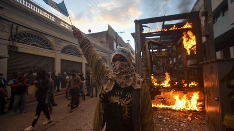 A bus stop burns as people protested in Guatemala City on Saturday
