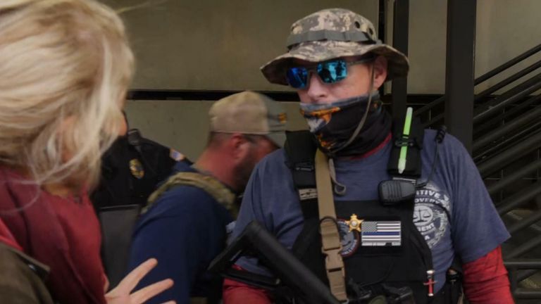 Rifle-wielding Trump supporters separated from Biden supporters