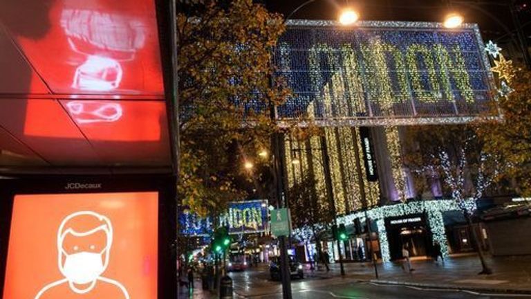 A screen advising the wearing of face masks is seen alongside Christmas lights on Oxford Street in central London, as England continues a four week national lockdown to curb the spread of coronavirus 18/11/2020