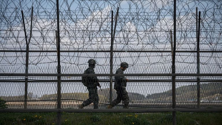 South Korean soldiers patrol along a barbed wire fence Demilitarized Zone (DMZ) separating North and South Korea, on the South Korean island of Ganghwa on April 23, 2020.