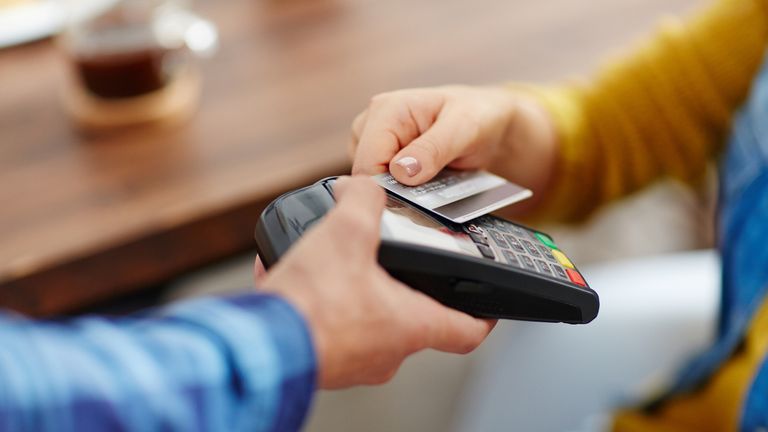 Gros plan d'un client méconnaissable choisissant le paiement sans contact par carte de crédit pendant que la serveuse accepte le paiement via la technologie NFC (gros plan d'un client méconnaissable choisissant le paiement sans contact par carte de crédit pendant que la serveuse accepte les payeurs