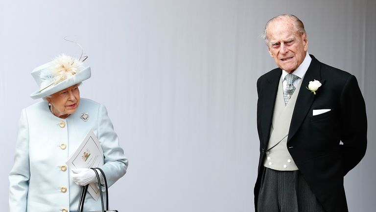 TOPSHOT - Britain&#39;s Queen Elizabeth II (L) and Britain&#39;s Prince Philip, Duke of Edinburgh (R) wait for the carriage carrying Princess Eugenie of York and her husband Jack Brooksbank to pass at the start of the procession after their wedding ceremony at St George&#39;s Chapel, Windsor Castle, in Windsor, on October 12, 2018. (Photo by Alastair Grant / POOL / AFP) (Photo credit should read ALASTAIR GRANT/AFP via Getty Images)