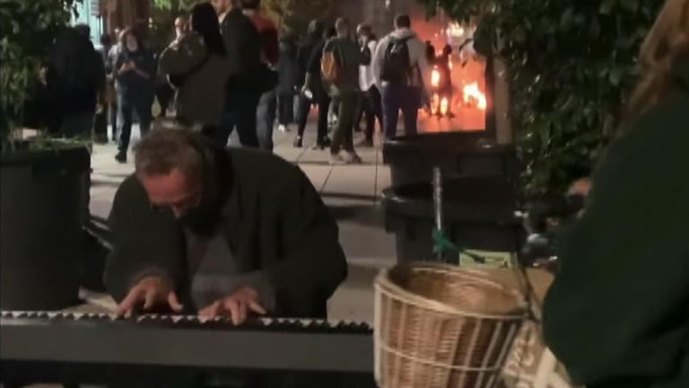 A pianist calmly continued to play as an anti-lockdown protest carried on behind him close to Catedral de Barcelona in Spain 