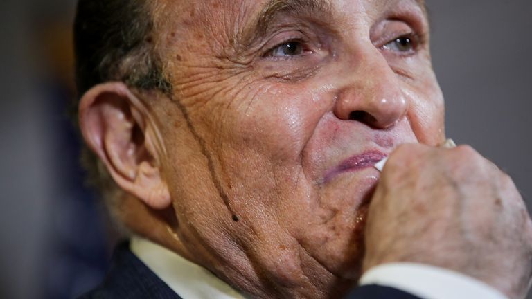 Trump&#39;s personal lawyer Rudy Giuliani appeared to be sweating a dark colour from his temples as he gave a press conference.
