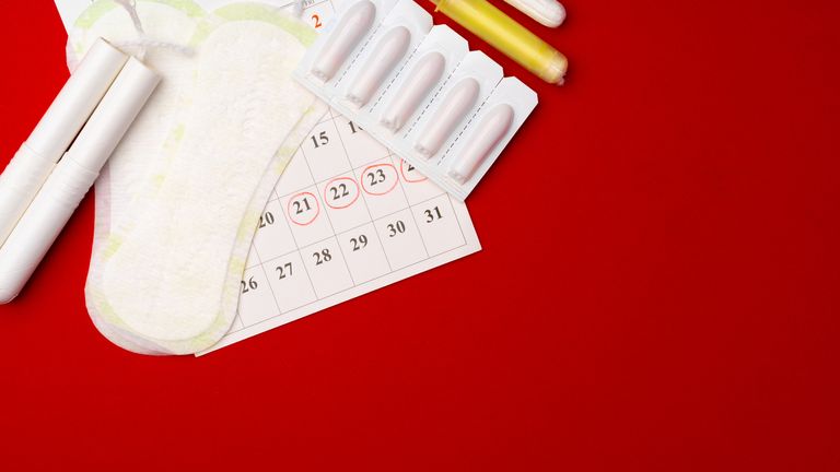 Menstruation calendar with sanitary pads and tampons, pills top view