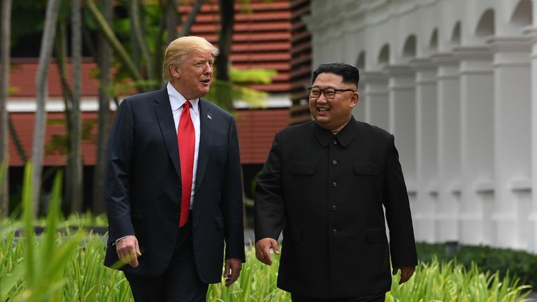 TOPSHOT - North Korea's leader Kim Jong Un (R) walks with US President Donald Trump (L) during a break in talks at their historic US-North Korea summit, at the Capella Hotel on Sentosa island in Singapore on June 12, 2018. - Donald Trump and Kim Jong Un became on June 12 the first sitting US and North Korean leaders to meet, shake hands and negotiate to end a decades-old nuclear stand-off. (Photo by SAUL LOEB / AFP) (Photo credit should read SAUL LOEB/AFP via Getty Images)
