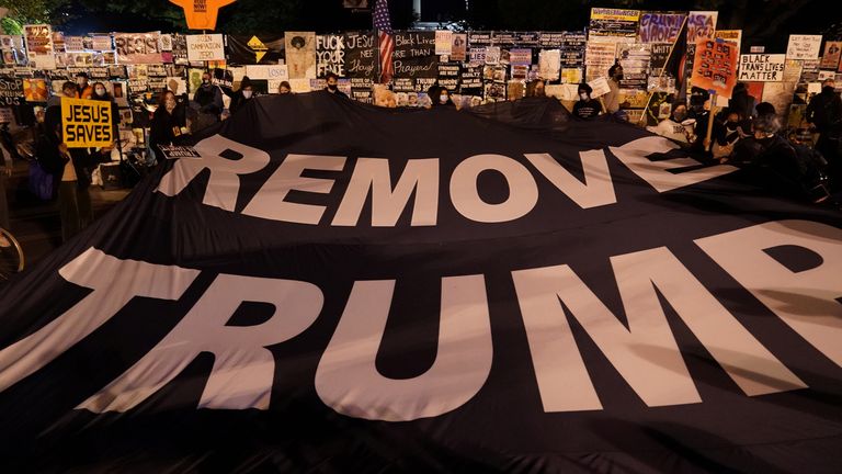 Protesters unfurl a banner in front of the White House