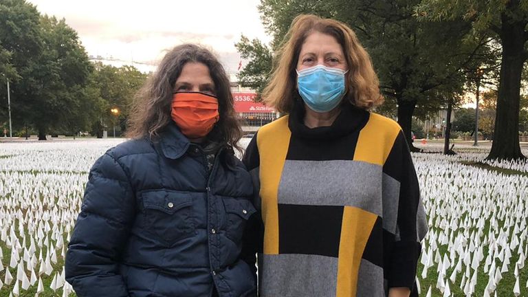 Flags planted in memory of people who have died of COVID in Washington DC - pictured: Lori Cooper (right) and sister Juli