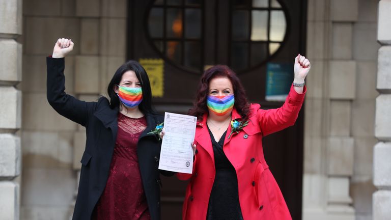 IMAGE PIXELATED BY PA PICTURE DESK Amanda McGurk (left) and Cara McCann outside Belfast City Hall after becoming the first couple in Belfast to convert their civil partnership into a marriage. From today same-sex couples across Northern Ireland are able to marry through the official conversion of existing civil partnerships following a change in the law.