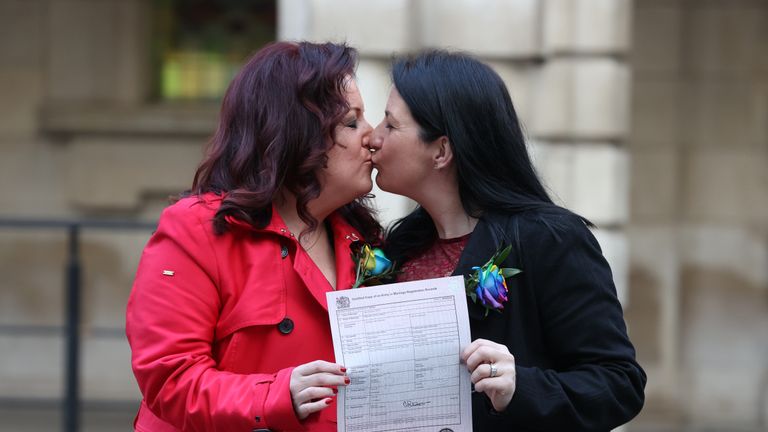 IMAGE PIXELATED BY PA PICTURE DESK Amanda McGurk (left) and Cara McCann outside Belfast City Hall after becoming the first couple in Belfast to convert their civil partnership into a marriage. From today same-sex couples across Northern Ireland are able to marry through the official conversion of existing civil partnerships following a change in the law.