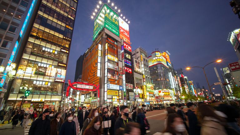 Pedestrians cross a street in Tokyo's Shinjuku area on December 12, 2020, as the city reported 621 new infections of the Covid-19 coronavirus. (Photo by Kazuhiro NOGI / AFP) (Photo by KAZUHIRO NOGI/AFP via Getty Images)