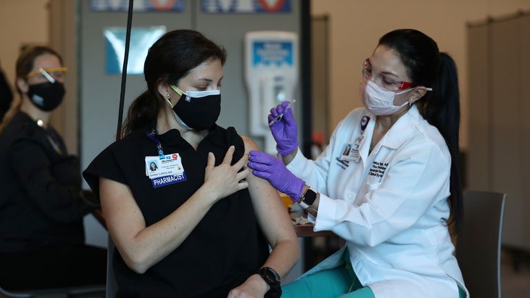 MIRAMAR, FLORIDA - DECEMBER 14:  Diana Carolina, a pharmacist at Memorial Healthcare System, receives a Pfizer-BioNtech Covid-19 vaccine from Monica Puga, ARNP at Memorial Healthcare System, on December 14, 2020 in Miramar, Florida. The hospital system announced it will be vaccinating their frontline workers that are in contact with COVID-19 patients. (Photo by Joe Raedle/Getty Images)