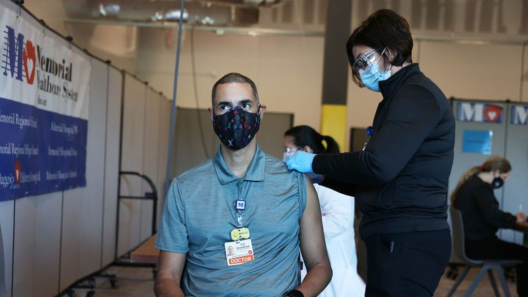 MIRAMAR, FLORIDA - DECEMBER 14: Brian Mendez, MD at the Memorial Healthcare System, receives a Pfizer-BioNtech Covid-19 vaccine from Colleen Claffey, RN at Memorial Healthcare System, on December 14, 2020 in Miramar, Florida. . The hospital system announced it will be vaccinating their frontline workers that are in contact with COVID-19 patients. (Photo by Joe Raedle/Getty Images)