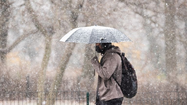 NEW YORK, NEW YORK - DECEMBER 09: A person walks with an umbrella in Central Park during the first snow of the season on December 09, 2020 in New York City. The pandemic has caused long-term repercussions throughout the tourism and entertainment industries, including temporary and permanent closures of historic and iconic venues, costing the city and businesses billions in revenue. (Photo by Noam Galai/Getty Images)