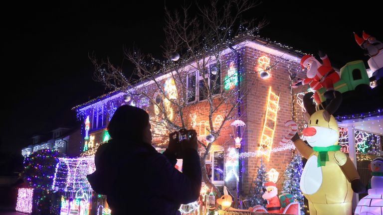 A member of the public takes a picture of the Christmas light display at a house on Saxifrage Way, Worthing.