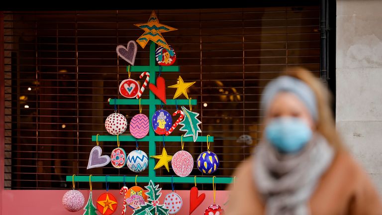 A pedestrian wearing a mask because of the novel coronavirus pandemic walks past a store front covered in Christmas decorations in central London on November 27, 2020, as life under a second lockdown continues in England. - The current lockdown in England has shuttered restaurants, gyms and non-essential shops and services until December 2, with hopes business could resume in time for Christmas. (Photo by Tolga Akmen / AFP) / CORRECTING DATE
The erroneous mention[s] appearing in the metadata of this photo by Tolga Akmen has been modified in AFP systems in the following manner: [November 27, 2020,] instead of [November 20, 2020,]. Please immediately remove the erroneous mention[s] from all your online services and delete it (them) from your servers. If you have been authorized by AFP to distribute it (them) to third parties, please ensure that the same actions are carried out by them. Failure to promptly comply with these instructions will entail liability on your part for any continued or post notification usage. Therefore we thank you very much for all your attention and prompt action. We are sorry for the inconvenience this notification may cause and remain at your disposal for any further information you may require. (Photo by TOLGA AKMEN/AFP via Getty Images)