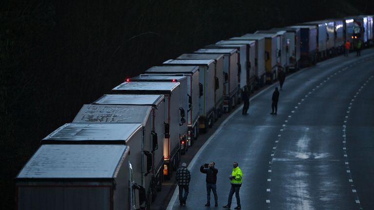 Drivers are seen by their freight lorries and goods vehicles stacked up queuing on a closed section of the M20 motorway which leads to the Port of Dover, near Ashford in Kent, south east England at sunrise on December 22, 2020, after a string of countries banned travel including accompanied freight arriving from the UK, due to the rapid spread of a more-infectious new coronavirus strain. - Britain's critical south coast port at Dover said on December 20 it was closing to all accompanied freight and passengers due to the French border restrictions "until further notice". (Photo by JUSTIN TALLIS / AFP) (Photo by JUSTIN TALLIS/AFP via Getty Images)