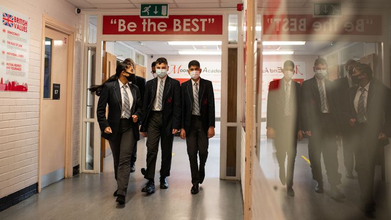 Year 10 pupils wear face masks as a precaution against the transmission of the novel coronavirus as they walk in a corridor at Moor End Academy in Huddersfield, northern England on September 11, 2020. - Millions of children across England have returned to school after the Covid-19 lockdown with many schools introducing measures to enable as safe an environment as possible. (Photo by OLI SCARFF / AFP) (Photo by OLI SCARFF/AFP via Getty Images)