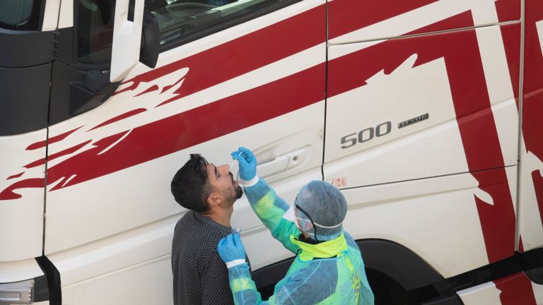 DOVER, UNITED KINGDOM - DECEMBER 24: A firefighter swabs a lorry driver to test for Covid-19 on December 24, 2020 in Dover, United Kingdom. Travel from the UK to France is gradually resuming after being suspended due to concerns about a new strain of Covid-19. The British government deployed its Track and Trace team to administer Covid-19 tests to lorry drivers waiting to cross at Dover. (Photo by Dan Kitwood/Getty Images)