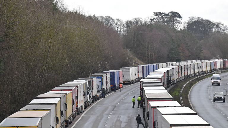 Freight lorries remain queued up on the M20 motorway, southbound, leading to the Port of Dover at Mersham in south east England on December 24, 2020, as rail and sea links between the UK and France are to remain open over Christmas to clear the backlog of thousands of trucks stranded by a new strain of coronavirus. - Thousands of European truckers on Wednesday spent a fourth night sleeping in the cabs of their vehicles, which are stuck close to the major cross-Channel port of Dover while the drivers wait to pass a Covid test, as required by France for travel. (Photo by JUSTIN TALLIS / AFP) (Photo by JUSTIN TALLIS/AFP via Getty Images)