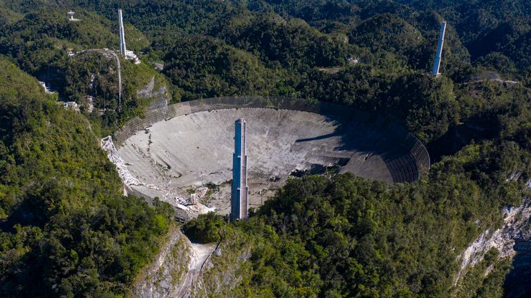 This aerial view shows damage to the Arecibo observatory after one of the main cables carrying the receiver broke in Arecibo, Puerto Rico, on December 1, 2020. - The radio telescope in Puerto Rico, which starred in the James Bond movie, collapsed.  Tuesday when the 900-ton receiving platform fell 450 feet (140 meters) and crashed onto the radio dish below.  (Photo by Ricardo Arduingo / AFP) (Photo by Ricardo Arduingo / AFP via Getty Images)