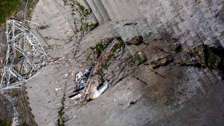 This aerial view shows the damage at the Arecibo Observatory after one of the main cables holding the receiver broke in Arecibo, Puerto Rico, on December 1, 2020. - The radio telescope in Puerto Rico, which once starred in a James Bond film, collapsed Tuesday when its 900-ton receiver platform fell 450 feet (140 meters) and smashed onto the radio dish below. (Photo by Ricardo ARDUENGO / AFP) (Photo by RICARDO ARDUENGO/AFP via Getty Images)