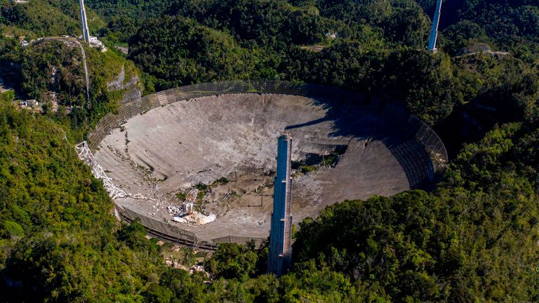 This aerial view shows damage to the Arecibo observatory after one of the main cables carrying the receiver broke in Arecibo, Puerto Rico, on December 1, 2020. - The radio telescope in Puerto Rico, which starred in the James Bond movie, collapsed.  Tuesday when the 900-ton receiving platform fell 450 feet (140 meters) and crashed onto the radio dish below.  (Photo by Ricardo Arduingo / AFP) (Photo by Ricardo Arduingo / AFP via Getty Images)