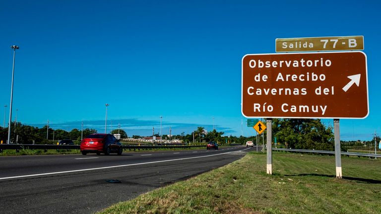 A road sign towards the Arecibo Observatory is seen on the highway in Arecibo, Puerto Rico on December 1, 2020. - The Arecibo Observatory telescope in Puerto Rico, which starred in the James Bond movie, collapsed on December 1, 2020 when a 900-ton receiving platform fell by 450 feet (140 feet) Meters) and crashed onto the radio dish below.  Engineers recently warned of the ramshackle mega-structure condition, and the US National Science Foundation (NSF) only announced last month that it