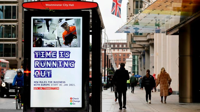 Pedestrians walk past an BTier 2 Coronavirus information displayed on an electronic advertising board at a bus stop in central London on December 14, 2020. - Britain&#39;s Prime Minister Boris Johnson and EU chief Ursula von der Leyen agreed Sunday to push on with post-Brexit trade talks despite the passing of a self-imposed deadline. Britain left the EU on January 31, 2020 after five decades of integration but a standstill transition period, under which it remains bound by the bloc&#39;s rules pending 