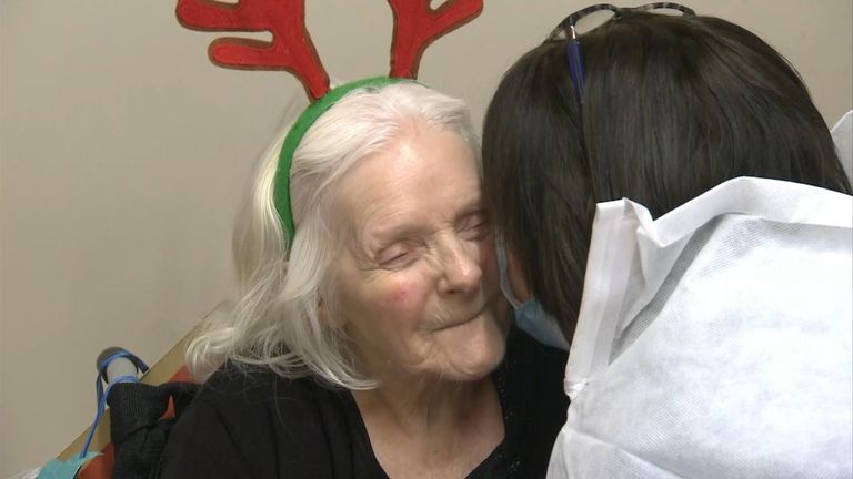 A care home resident gets a kiss from her daughter on Christmas Day.