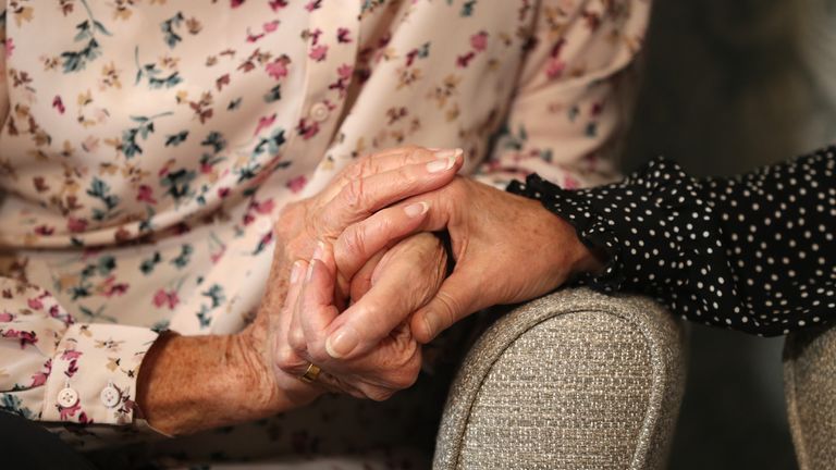 Care home resident Doreen (left) holds hands with her daughter Sandy