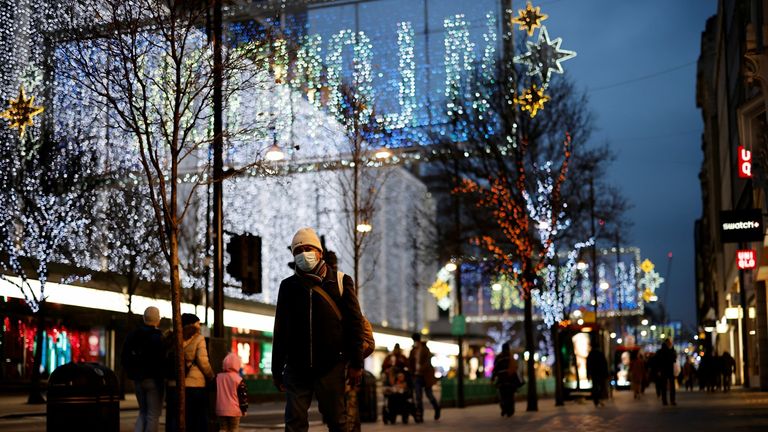 A pedestrian wearing a face mask or covering due to the COVID-19 pandemic, carries his purchases in carrier bags as he walks along Oxford Street in central London on December 22, 2020. - UK government borrowing continued to soar in November on emergency action to support the virus-hit economy which nevertheless rebounded stronger than expected in the third quarter, official data showed Tuesday. Government borrowing last month hit £31.6 billion ($41.8 billion, 34.2 billion euros), a record for No