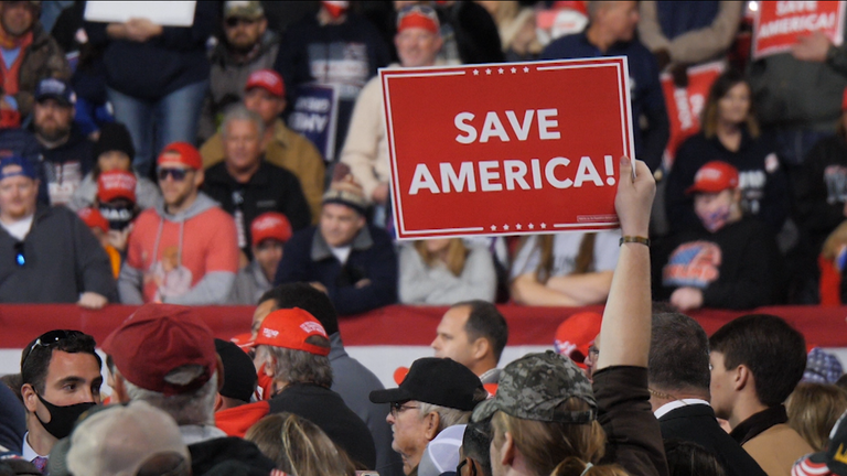 A man waves a placard at a Donald Trump rally in Valdosta, Georgia