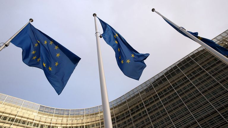 In this picture taken on December 25, 2020 flags of the European Union can be seen fluttering outside the European commission headquarters in Brussels