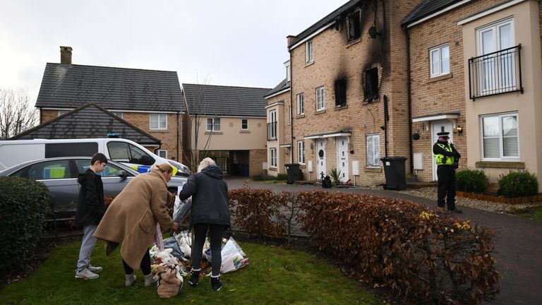 People lay flowers at the scene of a house fire on Buttercup Avenue, Eynesbury, Cambridgeshire, in which a three-year-old boy and a seven-year-old girl died. A 35-year-old woman and a 46-year-old were also injured in the fire at the three-storey house, which police believe broke out around 7am Thursday morning.