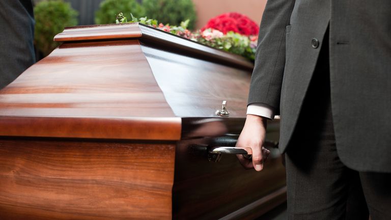 Funeral with coffin on a cemetery