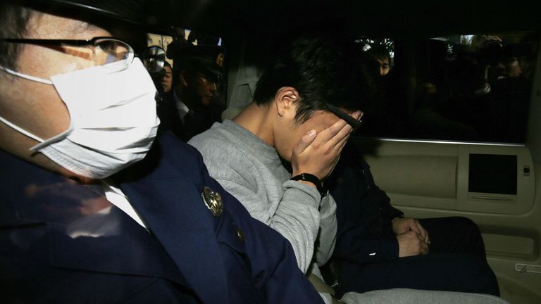 Suspect Takahiro Shiraishi (C) covers his face with his hands as he is transported to the prosecutor&#39;s office from a police station in Tokyo on November 1, 2017.  police found nine dismembered corpses rotting in his house, has confessed to killing all his victims over a two-month spree after contacting them via Twitter, media reports. / AFP PHOTO / JIJI PRESS / STR / Japan OUT (Photo credit should read STR/AFP via Getty Images)