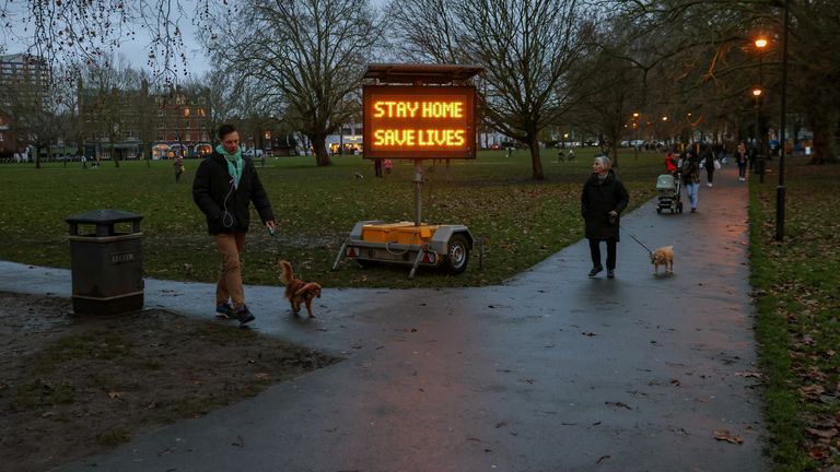 People walk past a newly placed sign on Eel Brook Common as EU countries impose a travel ban from the UK amid alarm about a rapidly spreading strain of coronavirus, in Fulham, London, Britain, December 21, 2020. REUTERS/Kevin Coombs
