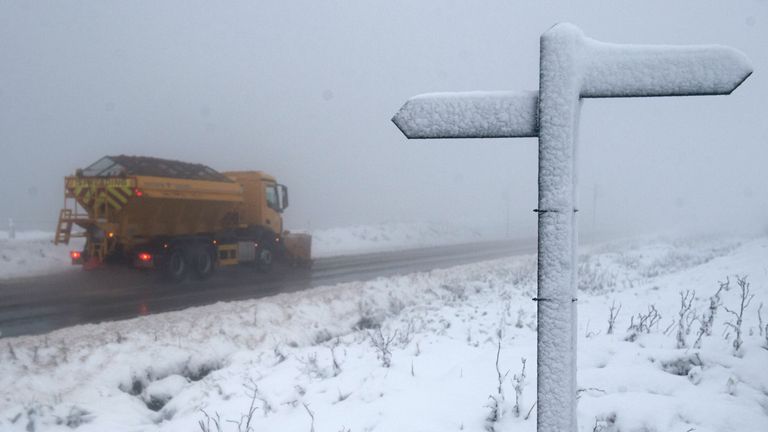 A sand truck passes a sign marking the Pennine Way near Manchester.