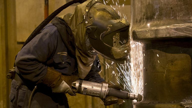 A grinder works on a freshly cast piece of steel in the foundry at Sheffield Forgemasters International Ltd