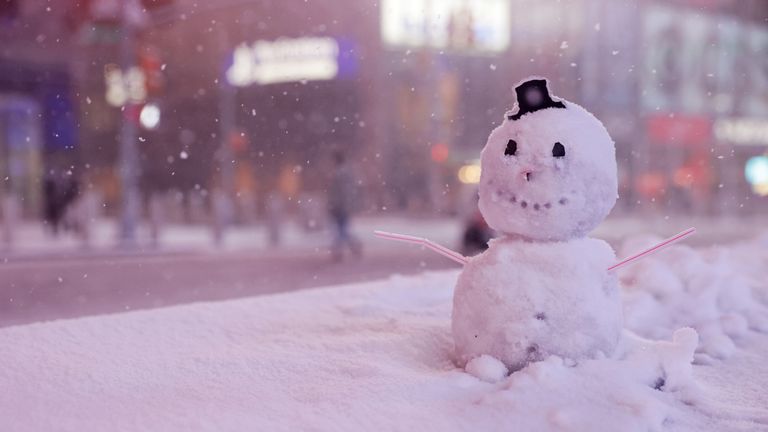 A snowman is seen as snow begins to fall in Times Square in New York City, New York