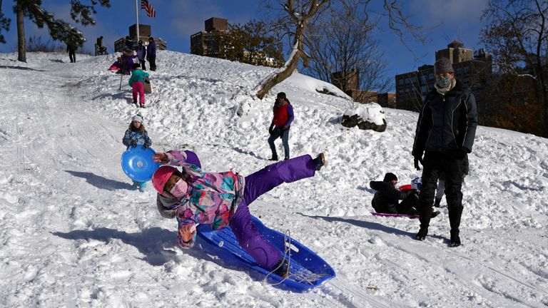 People play in the snow that fell during a Nor'easter storm amid the coronavirus disease (COVID-19) pandemic in New York City, New York, U.S., December 17, 2020. REUTERS/David 'Dee' Delgado