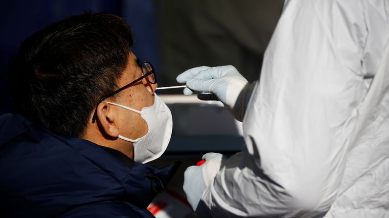 
A man undergoes coronavirus disease (COVID-19) test at a coronavirus testing site which is temporarily set up in front of a railway station on Christmas day in Seoul, South Korea, December 25, 2020. REUTERS/Kim Hong-Ji