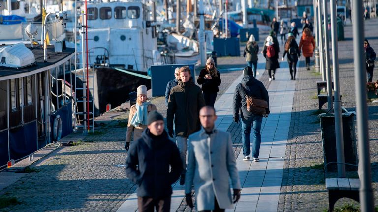 People stroll in the cold but sunny weather along Standvagen quayside in Stockholm, Sweden, on November 20, 2020, amid the ongoing coronavirus pandemic. (Photo by Fredrik SANDBERG / TT News Agency / AFP) / Sweden OUT (Photo by FREDRIK SANDBERG/TT News Agency/AFP via Getty Images)
