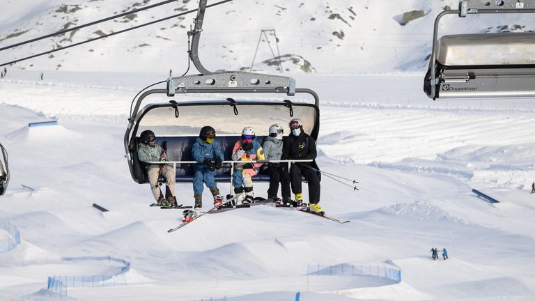 Skiers, some wearing protective face masks against the spread of the Covid-10 (novel coronavirus), ride a ski lift before hitting the slopes above the ski resort of Zermatt in the Swiss Alps on November 28, 2020. - As EU countries debate a bloc-wide ban on ski holidays to curb coronavirus infections, downhill enthusiasts may be tempted to head to non-member Switzerland, where the winter season is well underway. 
